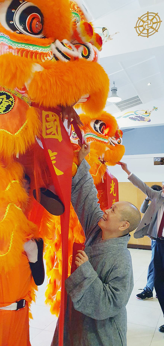 董事長悟觀法師與舞獅開心互動。