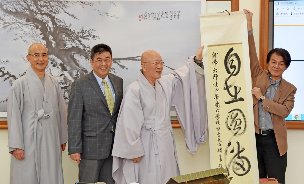 李校長致贈藝術設計學院黃智陽院長書法作品「自在圓滿」給韓國釜山安國禪院禪院長修弗大師(右二)。
