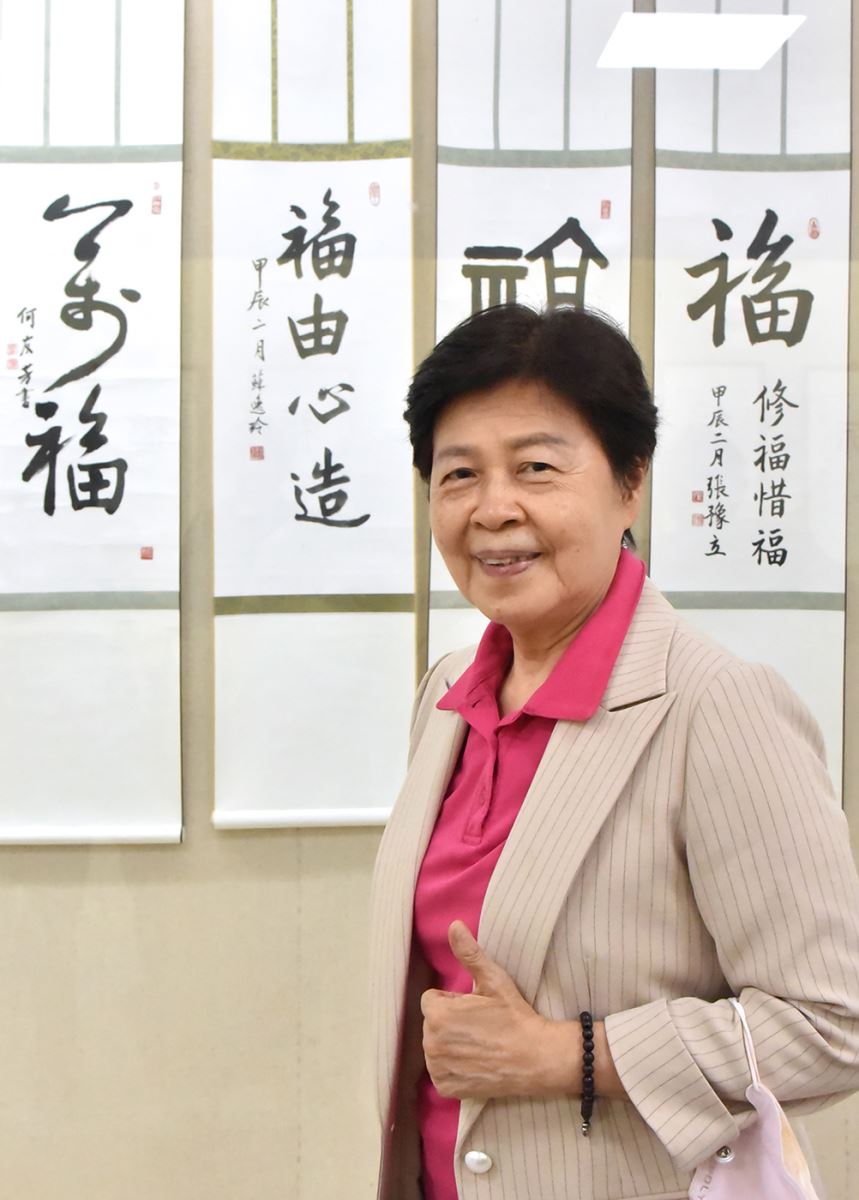前臺北榮民總醫院護理部督導長蘇逸玲與參展作品《褔由心造》合影。  