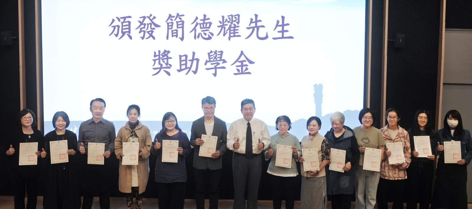 李天任校長（左7）向獲獎同學頒發「簡德耀先生依仁游藝獎助學金」證書。