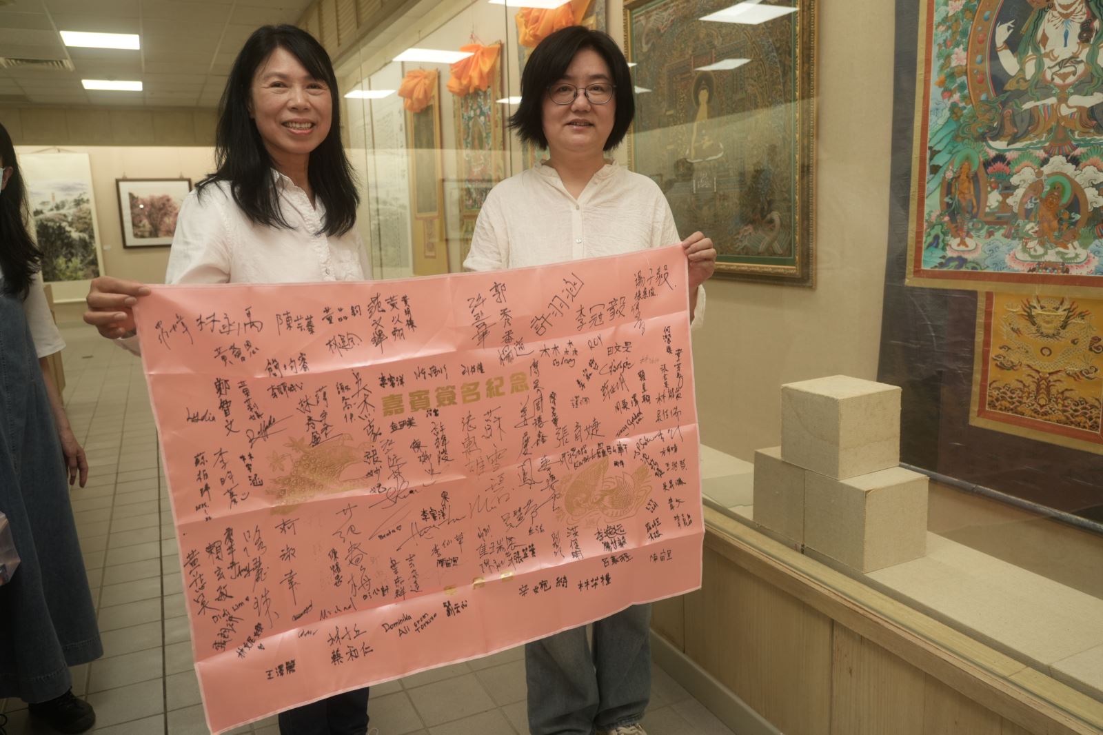 路麗珠（左）與王力紅（右）開心展示今年1月與詹春秋前往九份做公益的遊客簽名。