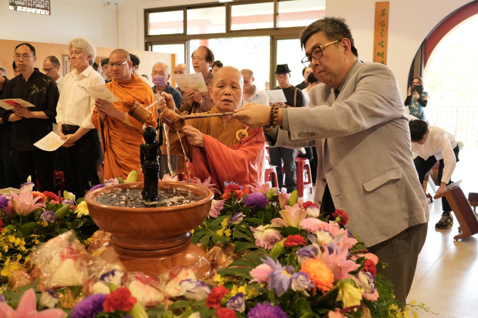 華梵大學董事長悟觀法師（左）與李天任校長帶領師生浴佛。