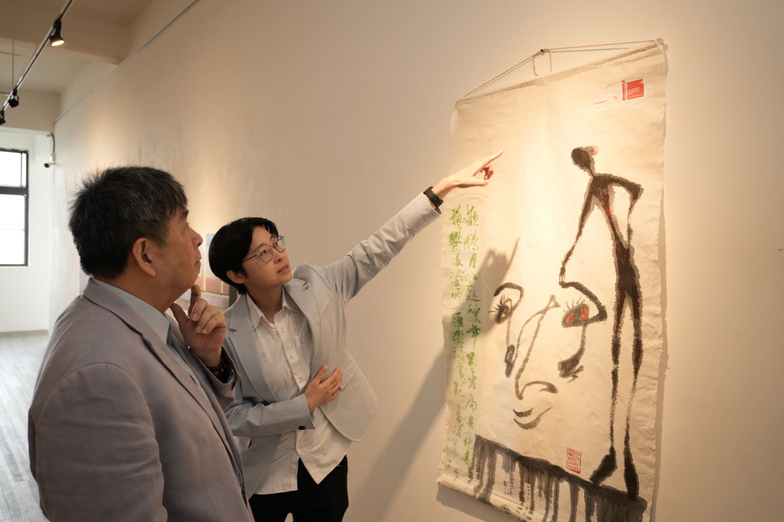 美術與文創學系楊侖助理教授（右）擔任策展人，為展覽進行導覽。