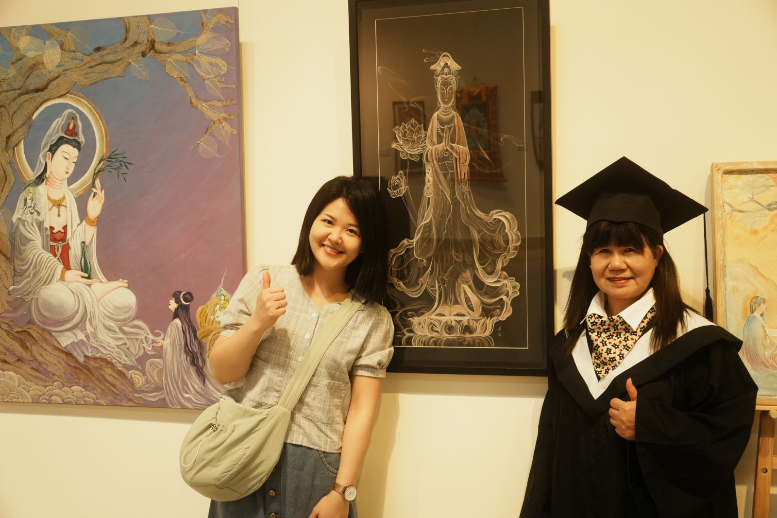 佛藝系巫春梅同學（右）與女兒在作品〈幻象觀音〉、〈點石成金〉前合影。